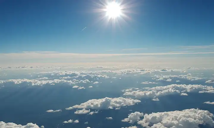 Tierra 3D, capas atmosféricas, sol, nubes, cielo azul, nubes puffy blancas, unos pocos aviones volando a la distancia, y un efecto sutil delgado de capa de ozono