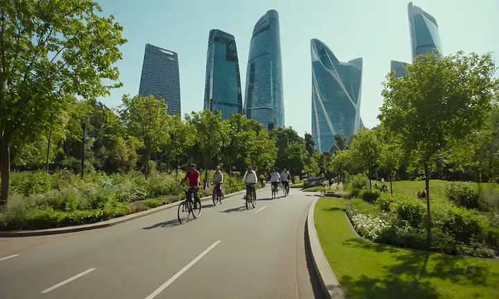 Una fusión de arquitectura moderna y vegetación, un paisaje urbano con rascacielos elegantes en medio de parques y jardines exuberantes, gente ciclándose o caminando en armonía con el entorno urbano, arte urbano vibrante, modos de transporte innovadores, y paneles solares o turbinas de viento en el fondo