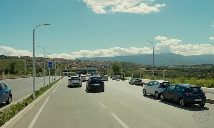 coches eléctricos cargando en estaciones públicas, ciudades y carreteras españolas, cielos soleados o nublados, paisajes urbanos y carreteras, paisajes verdes, arquitectura urbana, diseños elegantes de coches, recargar cables conectados, gente caminando cerca, cielo azul con pocas nubes, un vistazo del paisaje español