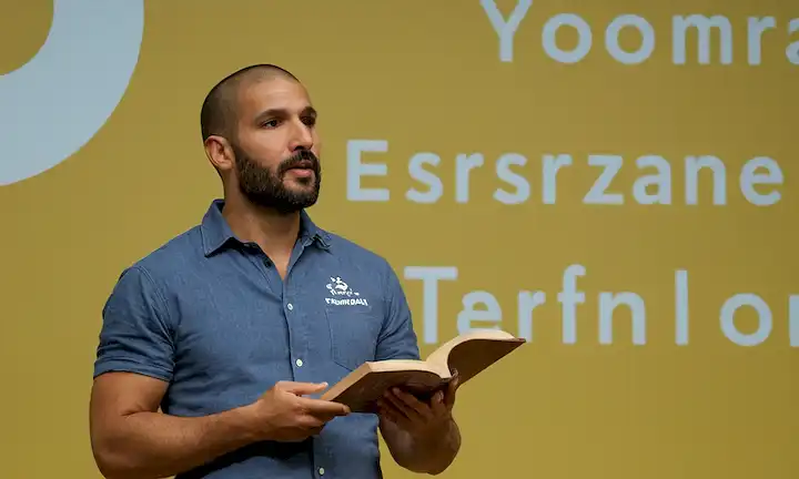 El hombre hablando con un libro en mano sobre mensajes inspiradores y transformadores. Este es un extracto de una presentación de Daniel Turan sobre el movimiento B Corporation para prácticas empresariales sostenibles y socialmente responsables. Elegí esta línea porque menciona tres temas principales (Las palabras de, Un mensaje, Un mensaje de esperanza y transformación) - títulos de un libro y una presentación sobre palabras (que probablemente sean relevantes para la discusión) así como una idea/tema (Esperanza y transformación). La parte final es bastante corta, pero transmite ideas importantes.