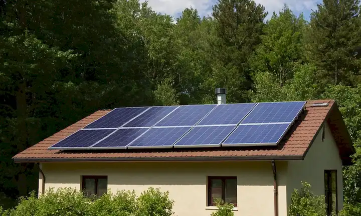 Paneles solares instalados en un techo soleado con árboles y paisajes al aire libre en el fondo, al tiempo que enfatizan la eco-amiabilidad y los beneficios de sostenibilidad. Esta guía tiene como objetivo proporcionar información integral para principiantes sobre la instalación de sistemas de energía solar para el uso eléctrico ecológico.