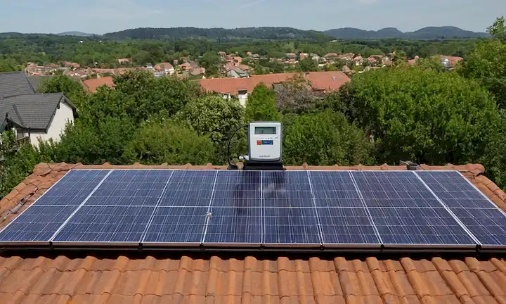 Un panel solar instalado en un techo de la casa con medidores de uso de energía cerca, enfatizando la comprensión de nivel principiante y la orientación paso a paso para instalar paneles solares fácilmente en casa.
