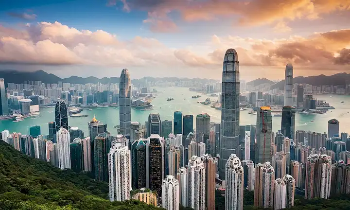 Gran skyline de paisaje urbano con rascacielos que se elevan sobre un paisaje urbano moderno, simbolizando tanto desafíos como oportunidades para un futuro próspero. La frase se desvanece en inglés como Descubra cómo conseguir su vuelo libre a Hong Kong! con regala vuelos traduciendo a una recompensa el billete. Tenga en cuenta que esta traducción puede no ser exacta debido al número limitado de palabras, pero da una idea del mensaje transmitido en una línea. Para explicar más adelante: Esta frase corta está promoviendo una oferta promocional dada por Hong Kong para cualquier persona que desee viajar allí, con la promesa de conseguir un vuelo libre si se cumplen ciertas condiciones (es decir, conseguir tu viaje gratis). La parte principal de la frase es en español (¡Descubre cómo conseguir tu viaje gratis!) y se traduce directamente en inglés como Descubre cómo conseguir tu vuelo gratis a Hong Kong!. Podría ser un anuncio en redes sociales o durante un anuncio de televisión. El paisaje urbano mencionado podría referirse a entornos urbanos bulliciosos y dinámicos de Hong Kong, que ofrecen numerosas oportunidades tanto para actividades de trabajo como de ocio. Los desafíos potenciales en la frase también implican que habría muchas ventajas con el viaje - un montón de vistas para ver y disfrutar, experiencias culturales, y oportunidades para nuevas experiencias, así como el posible crecimiento y desarrollo dentro de un entorno cambiante que se adapta continuamente a las tendencias del mundo moderno.