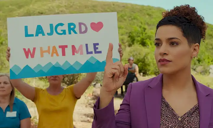Persona hablando apasionadamente, manteniendo un registro que lee LGBTQ+ con un gesto de mano habilitado de una transición femenina a hombre. En el fondo se trata de un paisaje colorido mientras discuten las luchas e importancia de la visibilidad para aquellos que se transfiere de las condiciones intersexuales.