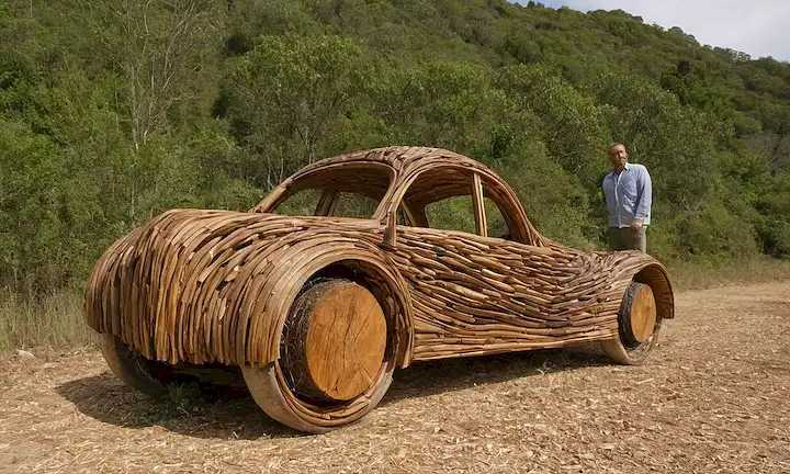 El artista contemporáneo Enrique Oliveira demuestra la artesanía de transformar la madera desechada en esculturas exquisitas que muestran la naturaleza reciclada del material. (Declarando brevemente detalles clave y una declaración sobre el trabajo sin sobrecomplicar la descripción)
