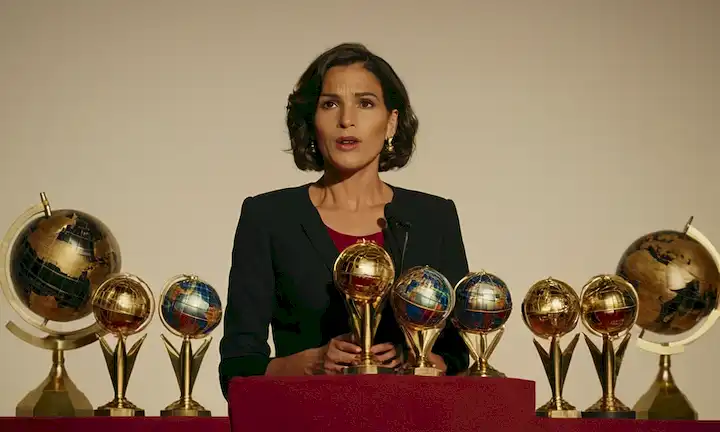 Mujer pronunciando un discurso impactante sobre el impacto de la carrera internacional de mujeres españolas al lado de un gran globo y varios premios.