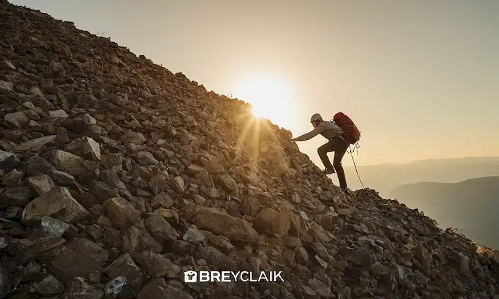 El hombre escalando sobre una montaña hecha de materiales reciclados para simbolizar el desarrollo sostenible. El título y la imagen se han combinado en una sola línea para la brevedad.