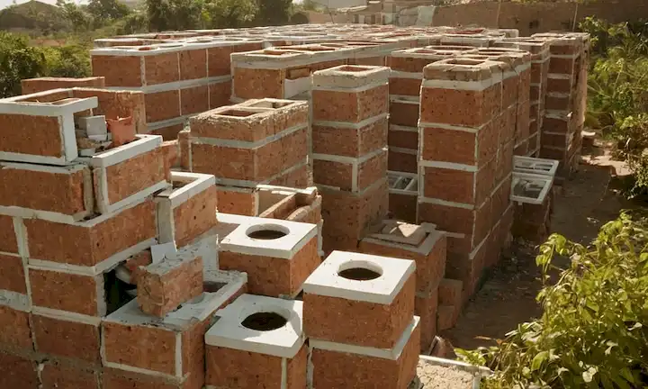 Herramientas y recursos que se unen para construir casas ecológicas resistentes al terremoto utilizando ladrillos de plástico reciclados, todo ello en medio de esfuerzos ecológicamente sostenibles.