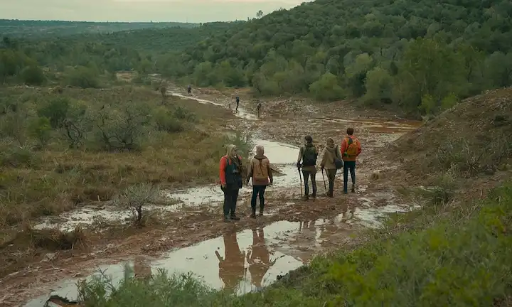 Un grupo de personas con paisajes acuosos, contaminación y preocupaciones ecológicas en primer plano, en medio de paisajes densamente poblados. Un movimiento ambiental sostenible, que aboga por la preservación de un hábitat natural en las afueras de Madrid contra posibles amenazas de extracción minera y expansión urbana.