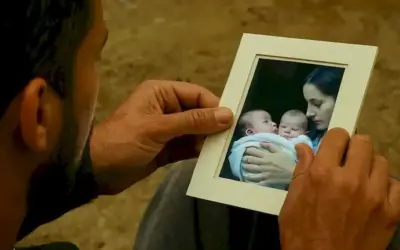 Hombre examinando una foto de una madre con su bebé