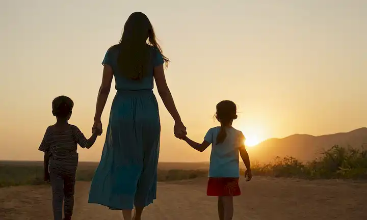 Mujer con niños agarrando las manos delante de un cielo de puesta del sol con los títulos de cuentos Un fúturo mejor (A Better Future) exhibido prominentemente. Esta breve descripción pone de relieve el camino y el impacto de un individuo dedicado a mejorar su comunidad mediante los esfuerzos humanitarios.
