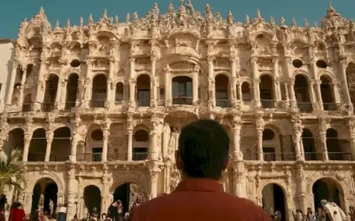 Aficionados a la arquitectura admirando la belleza de un edificio meticuloso elaborado como parte de un contexto cultural más grande. La frase está escrita en español y traducido al inglés como Ignacio Vicens: Arte