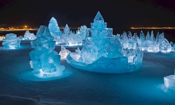 Un espectacular espectáculo de esculturas de hielo y deslumbrantes efectos de luz en la playa del Paraíso de Hielo en Reykjavik Islandia. La pantalla crea una escapada idílica junto al mar con efectos visuales impresionantes, donde la naturaleza y la tecnología se unen para encantar al público.