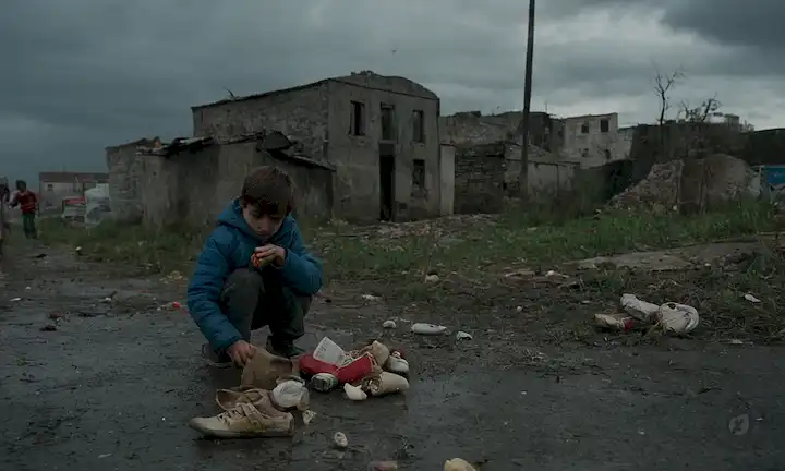 Calle descompuesta por la pobreza, niños jugando con chatarras, zapatos desgastados, embalaje de alimentos descartados, juguetes rotos, edificios antiguos, cielos grises, pobrezas sombra cayendo en caras, desesperanza, descuido, desigualdad social velo oscuro