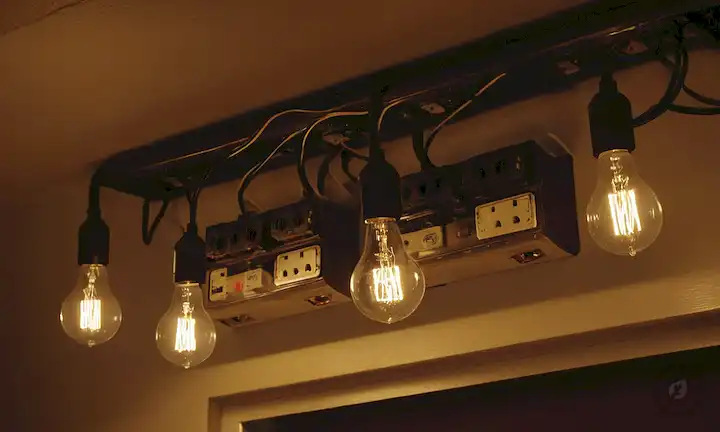 Bombillas iluminadas, medidores eléctricos, tomas de corriente y interruptores, con alambres y conexiones en un diseño sencillo y organizado