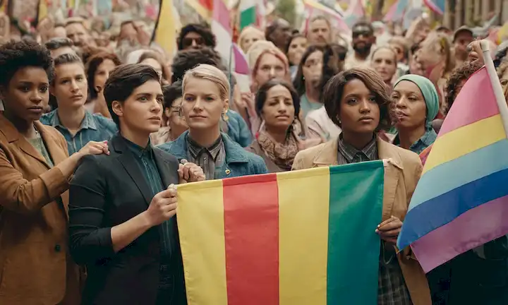 Representación conceptual de identidad de sisgendra con diversidad de individuos que sostienen banderas de diferentes géneros.