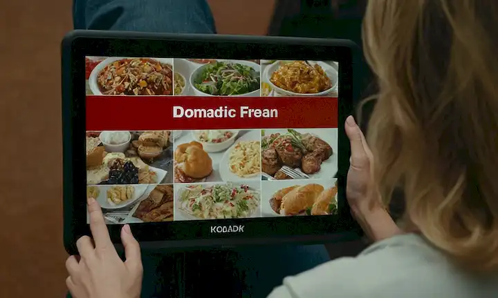 Persona eligiendo un elemento de menú en un ordenador de pantalla táctil digital para una experiencia gastronómica todo lo que puedas comer, con el título sobre ellos en letras negritas y de bloque. La frase se refiere a un documental o seminario popular que explora principios democráticos relacionados con las opciones alimentarias y los procesos de toma de decisiones. Sin embargo, esta versión abreviada no capta eficazmente la amplitud total de estos conceptos.