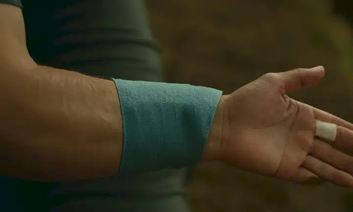 Una persona sosteniendo un paquete de hielo en el brazo con una mordedura de mosquito sutil visible.