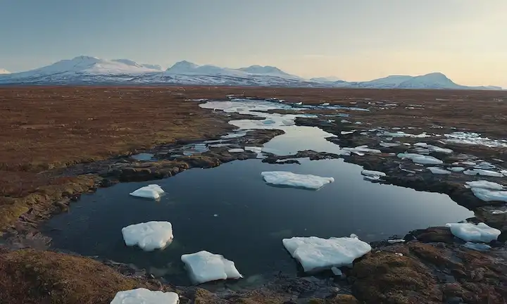 Paisaje de tundra ártico con permafrost derretido, bloques de hielo de tala, agua goteante, grietas heladas y suelo expuesto