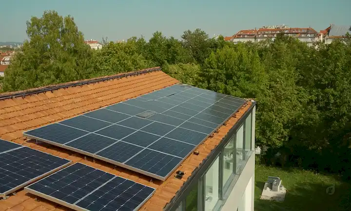 Soleado cielo con paneles solares, techo con baldosas, gente instalando o inspeccionando, metros de energía solar, jardín o árboles en primer plano, edificio de arquitectura moderno, conceptos de energía renovable