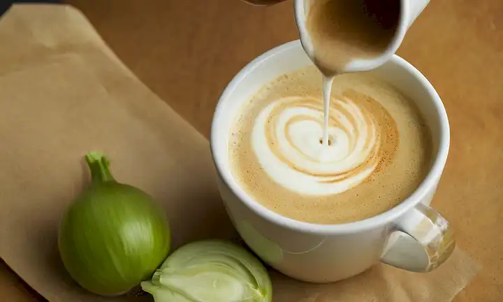 Vinagre Celery: alternativa sostenible al vinagre blanco regular para su crema agria y leche de cebolla, con una persona que derrama la mezcla en una taza. (Esta descripción supone que la crema agria y latte de cebolla es un contexto relevante o elemento alimenticio).