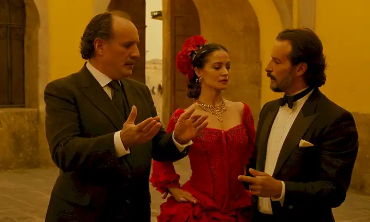 Autor discutiendo el baile flamenco se mueve en detalle durante una entrevista con un hombre vestido como la figura de Sevillá.