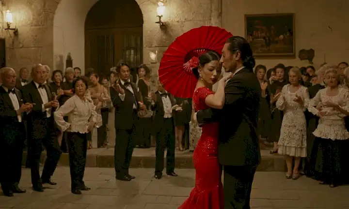 Calle española con un espectáculo flamenco, acompañada de una imagen con el artista Yoichiro Yamadas devoción a la pasión del flamenco. El texto explica cómo su fascinación por la forma de arte lo llevó a crear obras icónicas en España que han resonado en todo Japón.